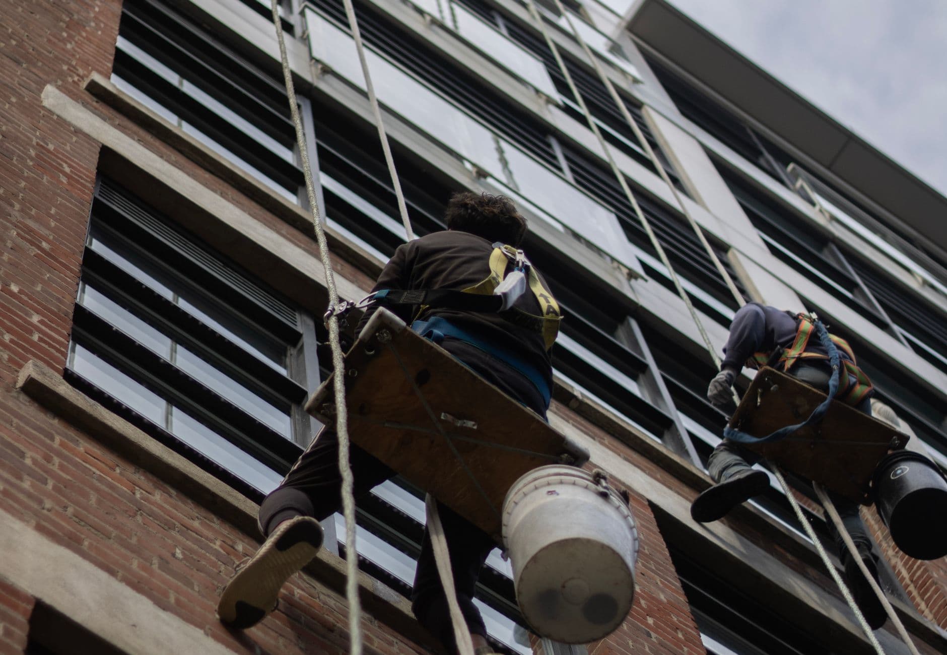 High-rise window cleaning by rope access Rope-access technicians cleaning the glass face of a high-rise building at height